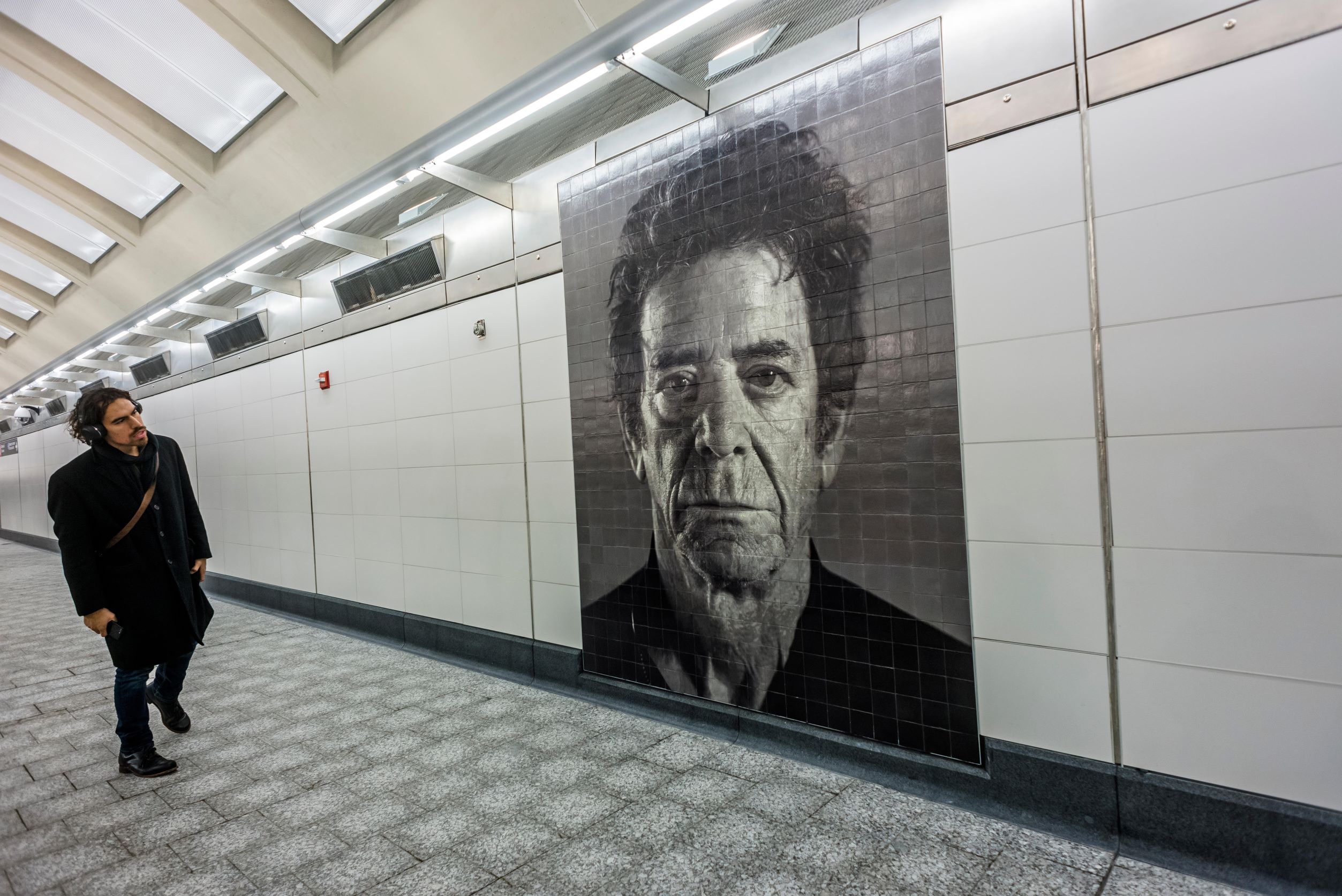 A passenger appreciates a mosaic mural of Lou Reed by artist Chuck Close. Stacy Walsh Rosenstock/ Alamy