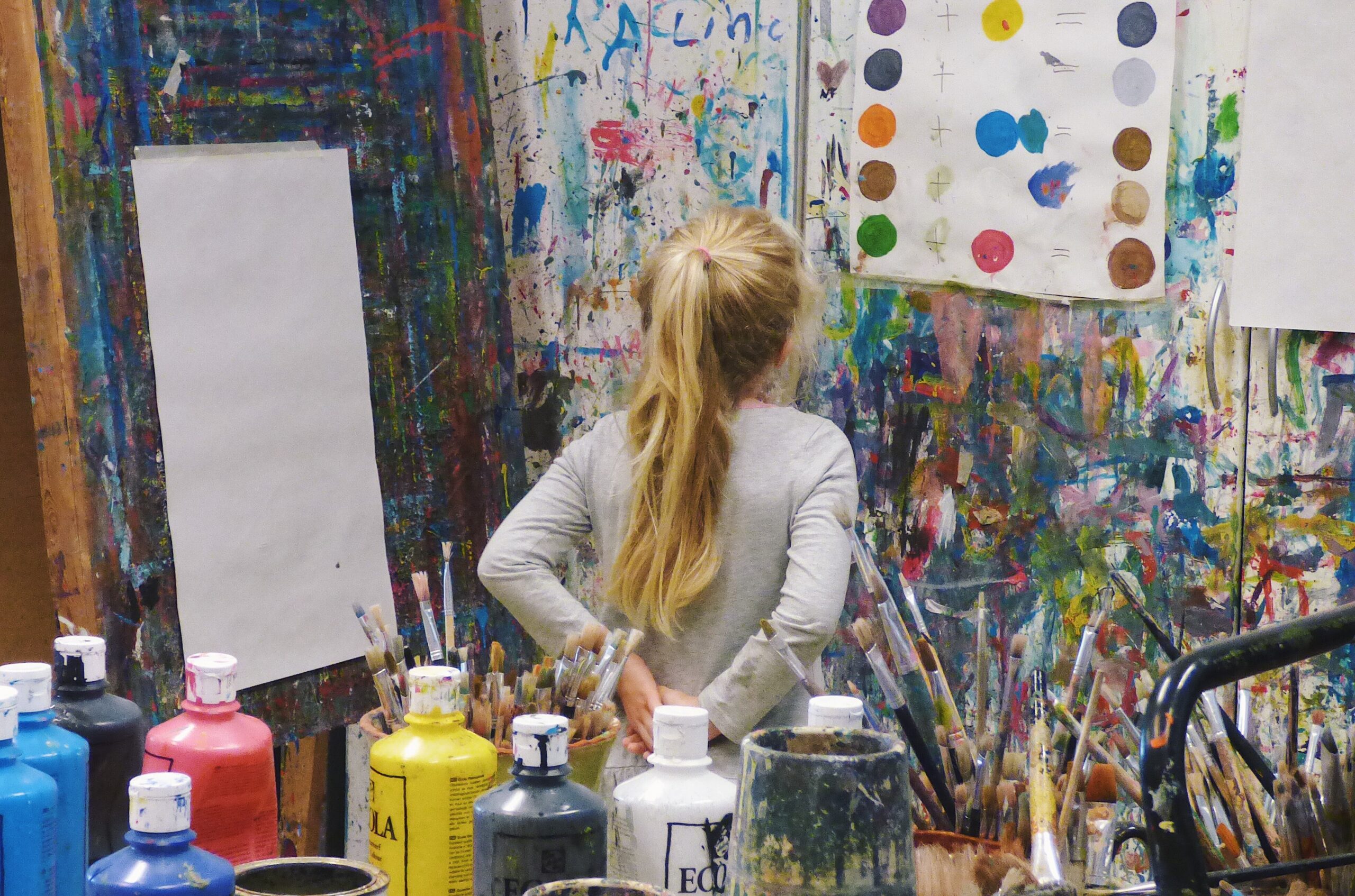 student in painting class observing her work