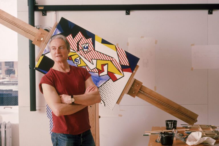 Roy Lichtenstein, American pop artist, standing in front of one of his works. Science History Images / Alamy Stock Photo