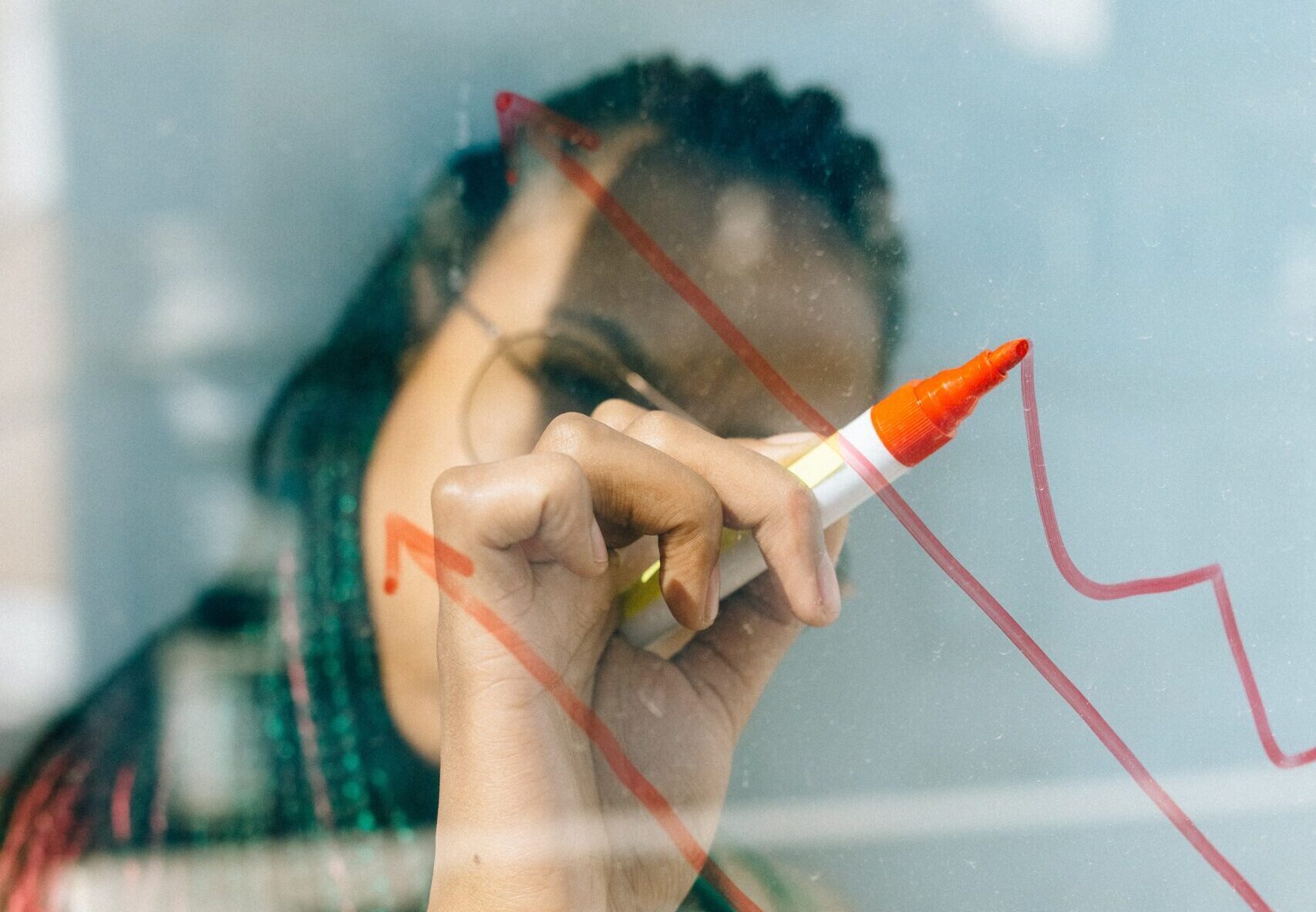 woman working out an investment returns graph on a white board