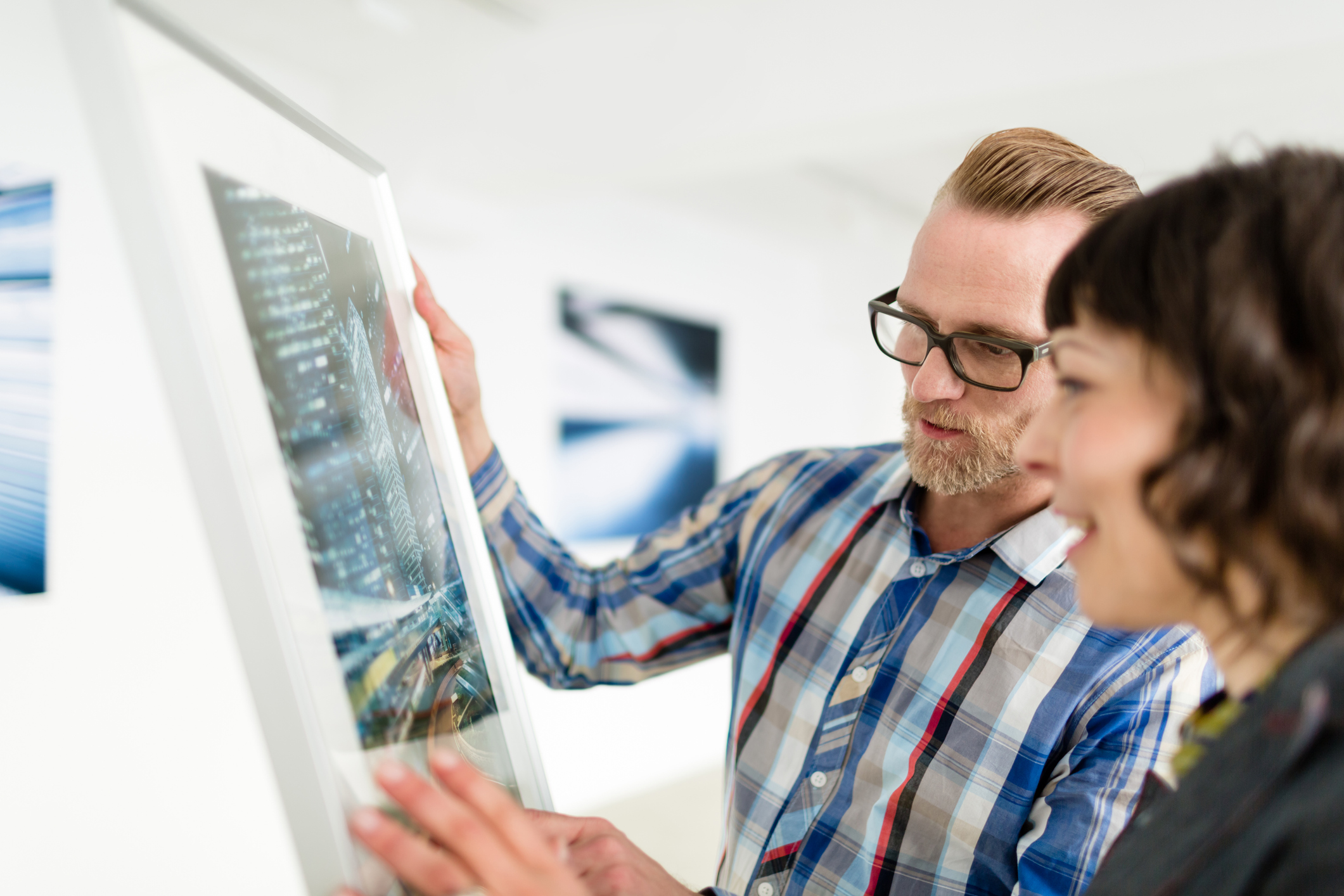 Artist and Woman looking at artwork in gallery to buy