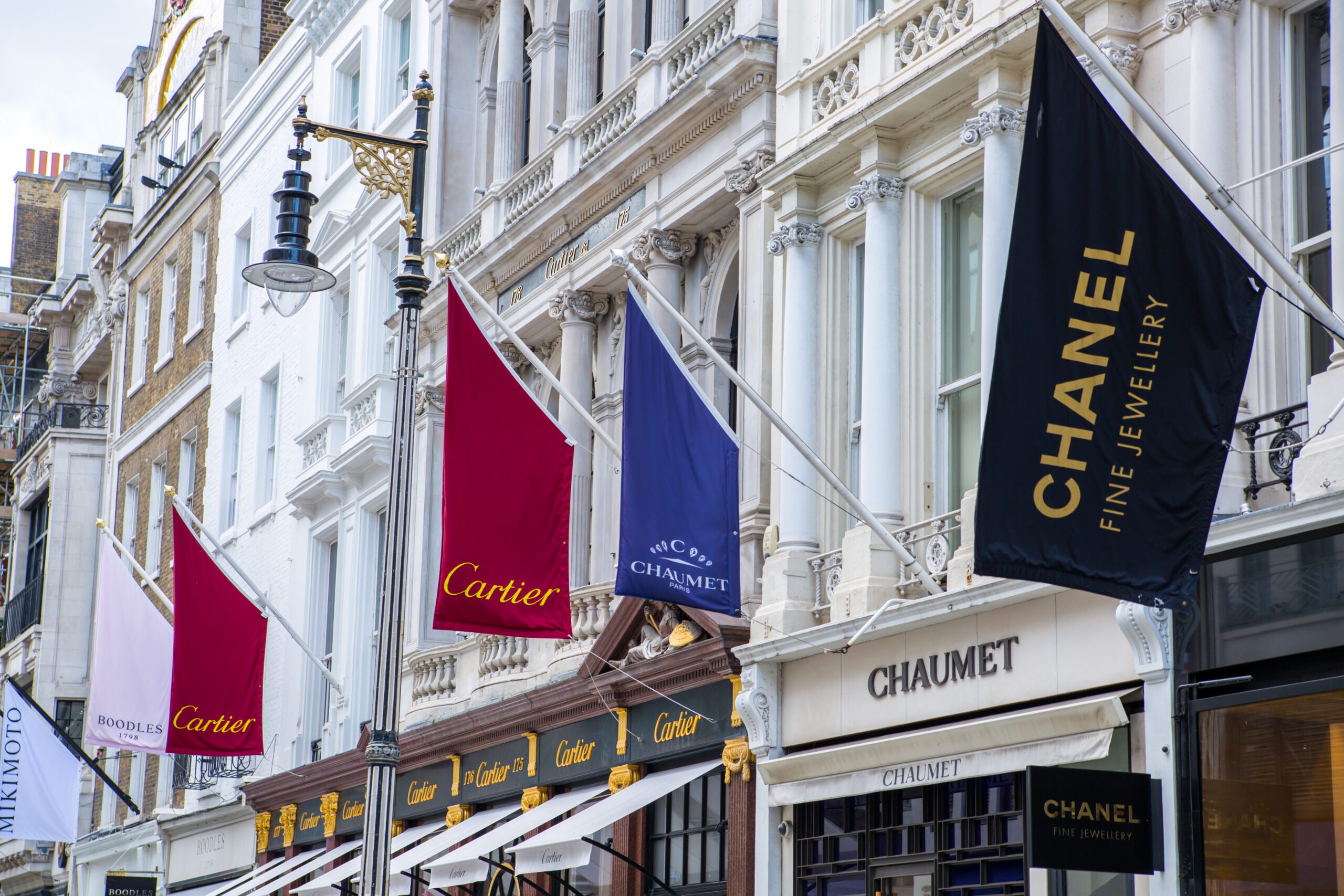 London, UK - August 13, 2019: Old Bond street view with flags of famous fashion houses. Bond Street is a major shopping street in the West End of London for luxury designer brands