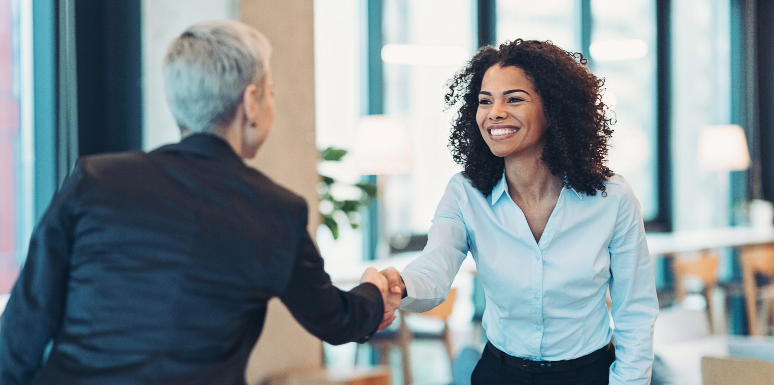 Two business women shaking hands